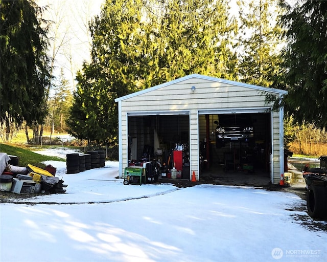 snow covered garage with a detached garage