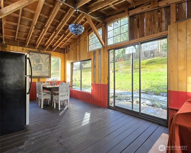 unfurnished sunroom featuring lofted ceiling with beams