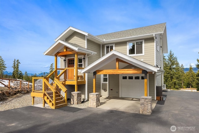 view of front facade with an attached garage, driveway, and a shingled roof