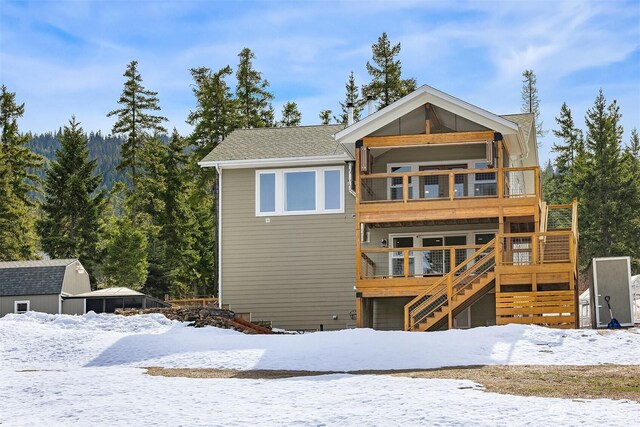 view of front of home with a balcony, stairway, and a wooden deck