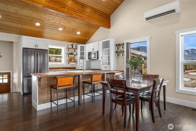 dining area featuring dark wood-style floors, plenty of natural light, wooden ceiling, and a wall unit AC