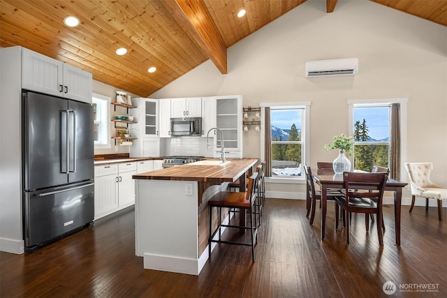 kitchen featuring open shelves, stainless steel appliances, a wall mounted air conditioner, wood counters, and tasteful backsplash