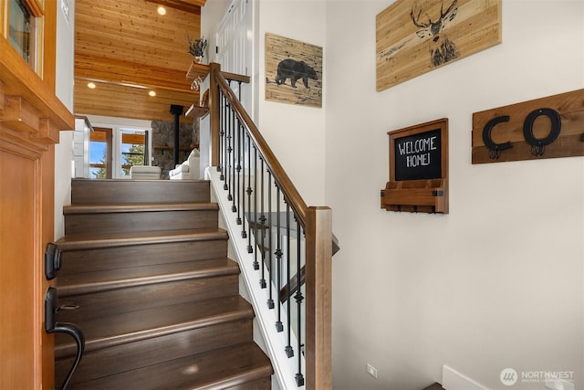 staircase featuring recessed lighting, a towering ceiling, and wooden ceiling