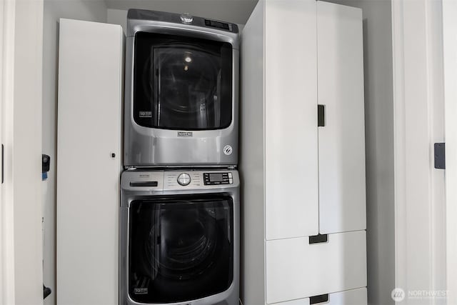 clothes washing area with stacked washer and clothes dryer and laundry area