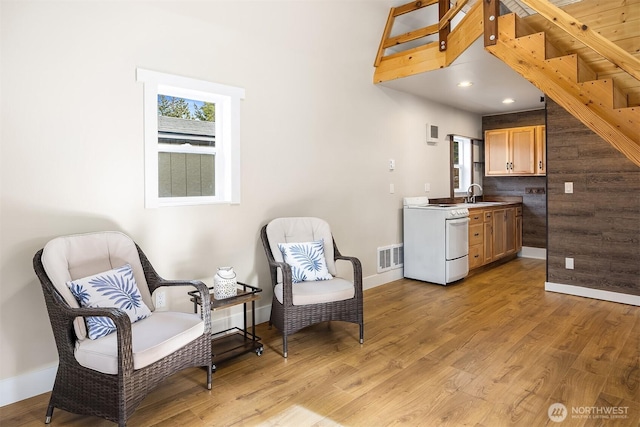 living area with recessed lighting, baseboards, visible vents, and light wood-type flooring