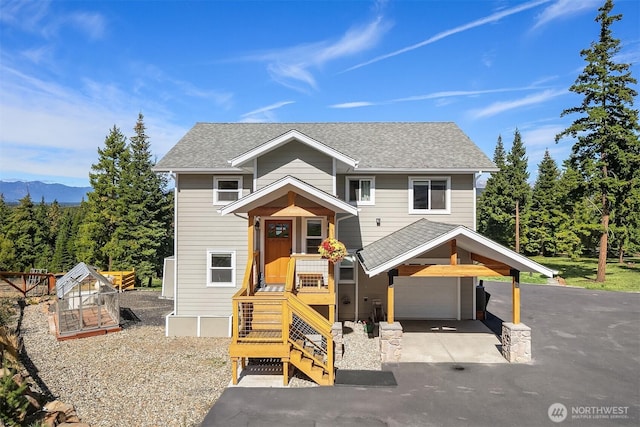 view of front of property with an attached garage, aphalt driveway, and roof with shingles
