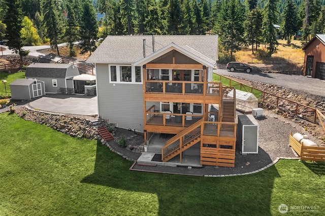 back of house featuring stairway, a wooden deck, fence, and a lawn