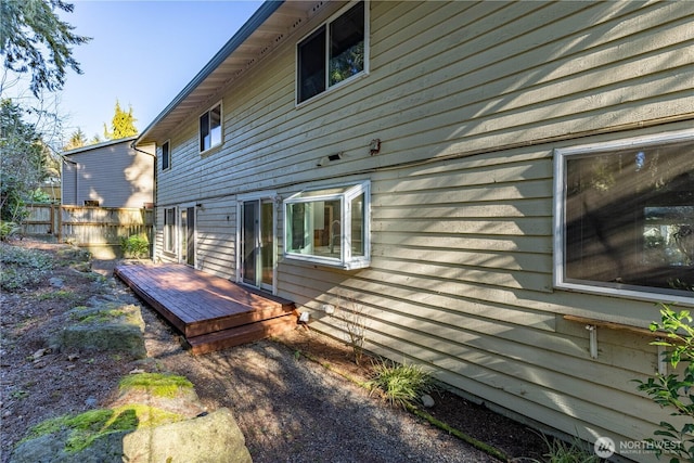 view of side of home featuring fence and a wooden deck