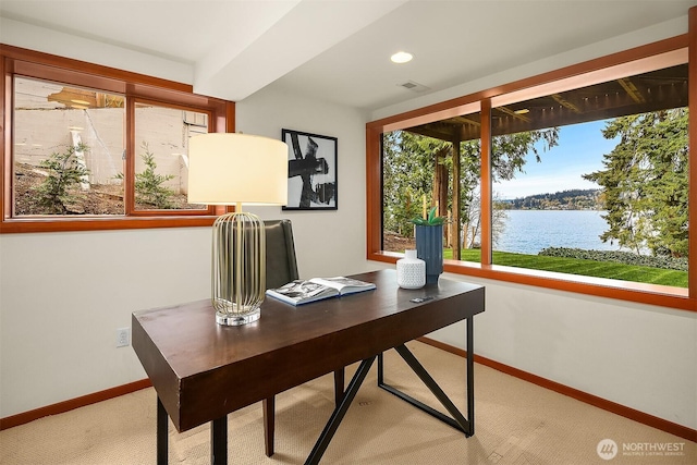 carpeted office space featuring recessed lighting, a water view, and baseboards