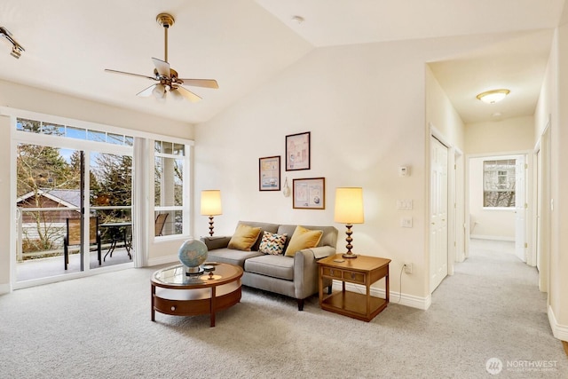 living room with light carpet, ceiling fan, baseboards, and vaulted ceiling