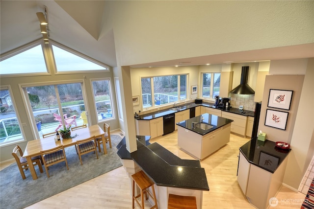 kitchen featuring a center island, black dishwasher, a sink, and dark countertops