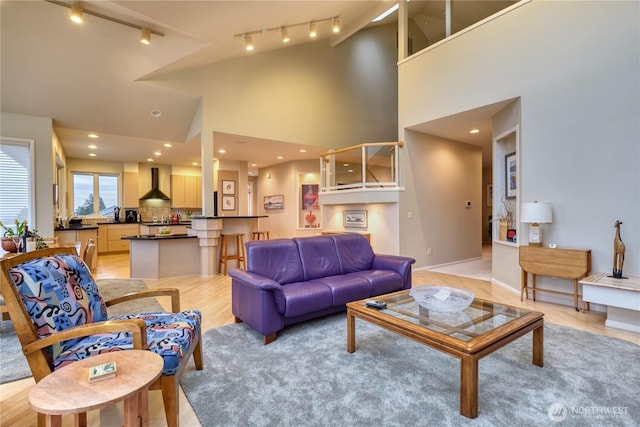 living room featuring light wood-style floors, recessed lighting, and high vaulted ceiling