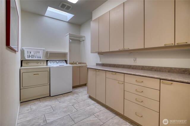 clothes washing area featuring a skylight, cabinet space, visible vents, a sink, and independent washer and dryer