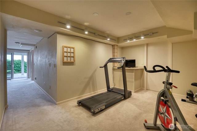 exercise room with light carpet, track lighting, and baseboards