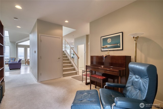 living area featuring recessed lighting, stairway, and light colored carpet