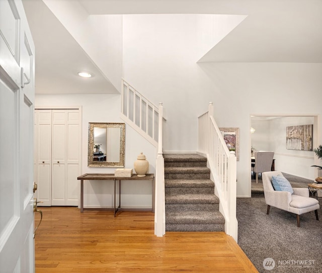 stairway with wood finished floors and recessed lighting