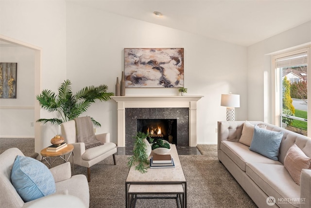 living room with lofted ceiling, baseboards, dark colored carpet, and a high end fireplace