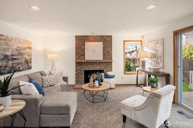 carpeted living area with a fireplace, visible vents, a wealth of natural light, and recessed lighting