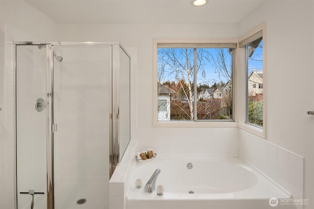 bathroom with a shower stall and a bath