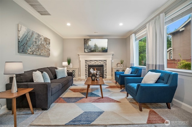 living area featuring baseboards, visible vents, crown molding, and a stone fireplace