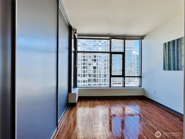 empty room featuring dark wood-style flooring and baseboards