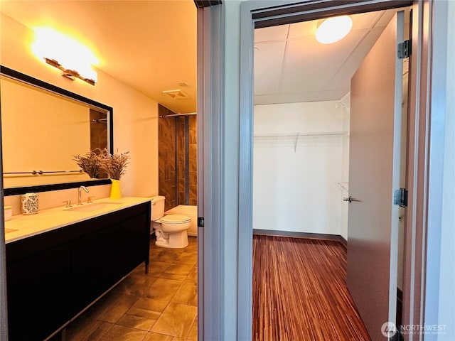 bathroom featuring toilet, a spacious closet, visible vents, and vanity