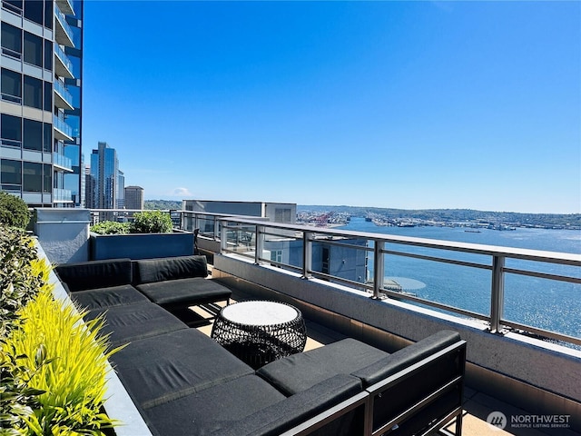 balcony with a water view, an outdoor living space, and a city view