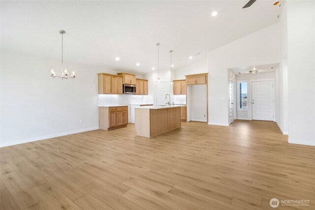 1138 8th Ave NE, Ephrata, WA 98823 - kitchen featuring a kitchen island with sink, light countertops, a sink, stainless steel microwave, and open floor plan