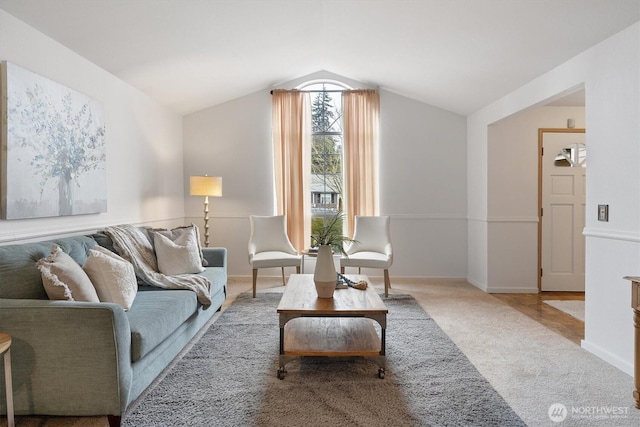 living room with vaulted ceiling, baseboards, and light colored carpet