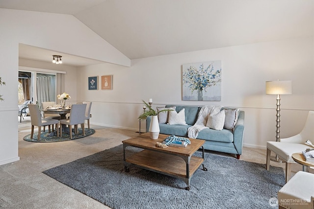 carpeted living area featuring vaulted ceiling and baseboards