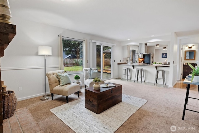 living area featuring recessed lighting, light carpet, and baseboards