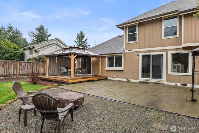 rear view of property featuring a deck, fence, a gazebo, crawl space, and roof with shingles