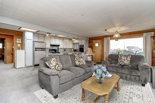 living room featuring light colored carpet and wood walls