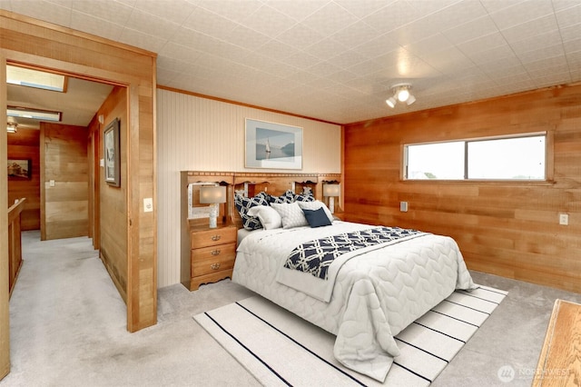 bedroom featuring wooden walls and light colored carpet