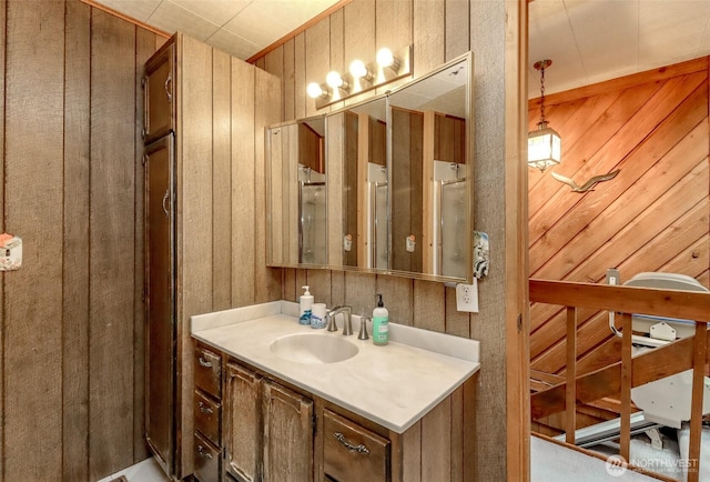 bathroom featuring wood walls and vanity