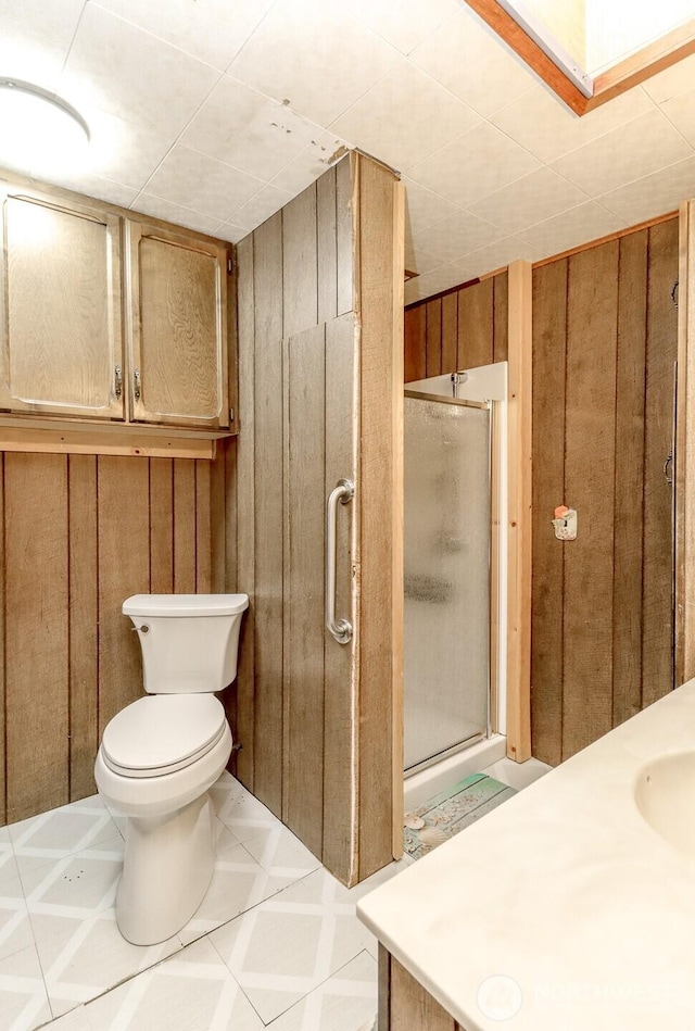 bathroom with wood walls and a shower stall