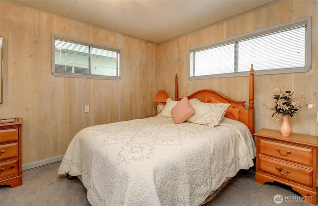 bedroom with carpet floors and wood walls