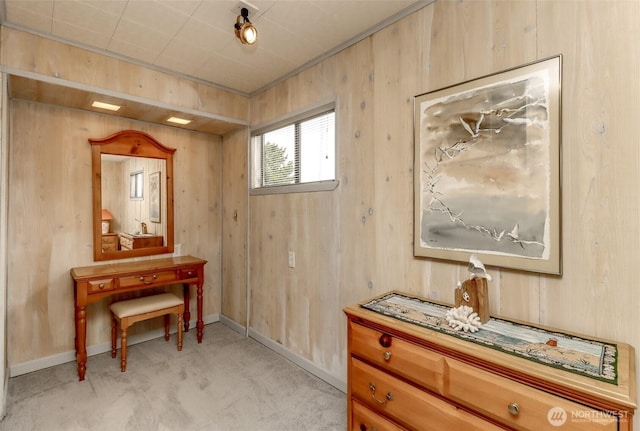 interior space with light carpet, baseboards, and wooden walls