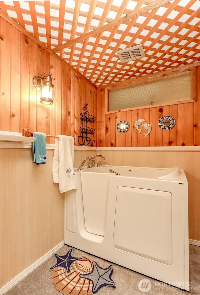 laundry room with washer / dryer, visible vents, and wooden walls