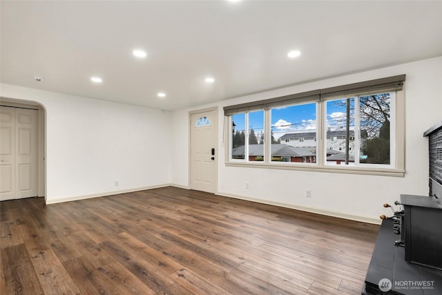 unfurnished living room featuring recessed lighting, wood finished floors, and baseboards