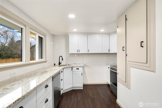 kitchen featuring stainless steel appliances, backsplash, a sink, and dark wood finished floors