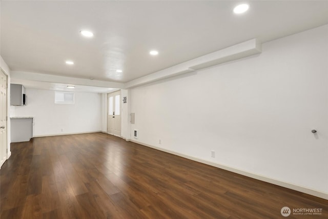 unfurnished living room featuring baseboards, dark wood-style flooring, and recessed lighting