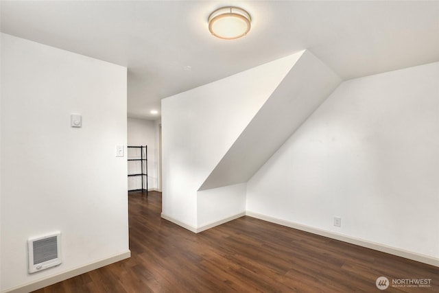 bonus room with heating unit, baseboards, and wood finished floors