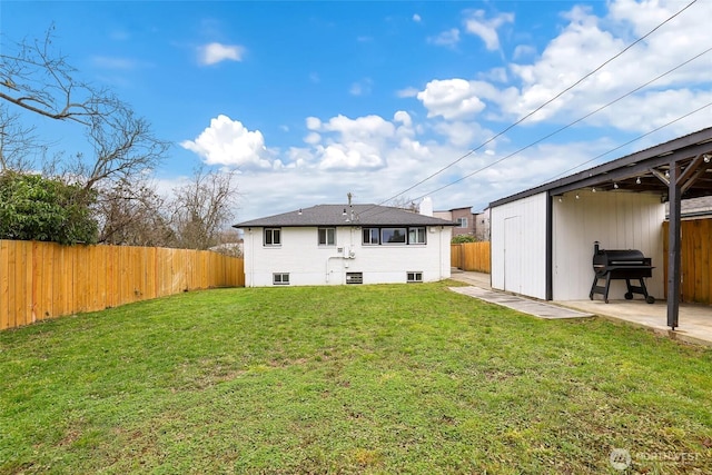 rear view of property with a patio area, a fenced backyard, and a yard