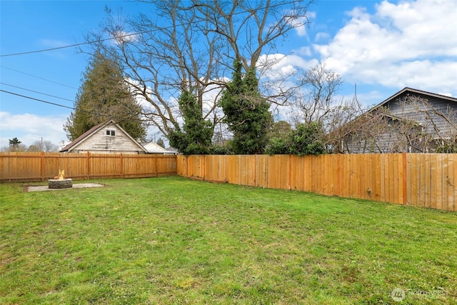 view of yard featuring a fire pit and a fenced backyard