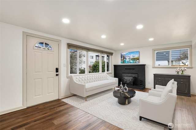 living area featuring baseboards, wood finished floors, and recessed lighting