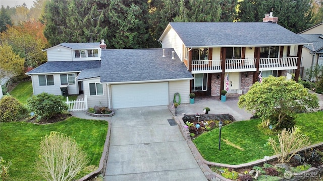 view of front of property with an attached garage, driveway, a chimney, and a front lawn