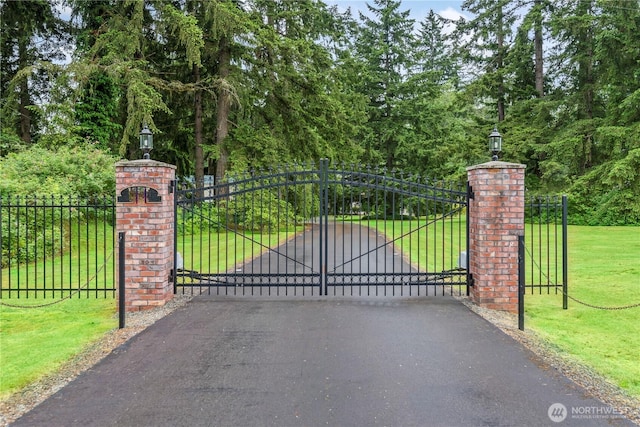 view of gate featuring a yard and fence