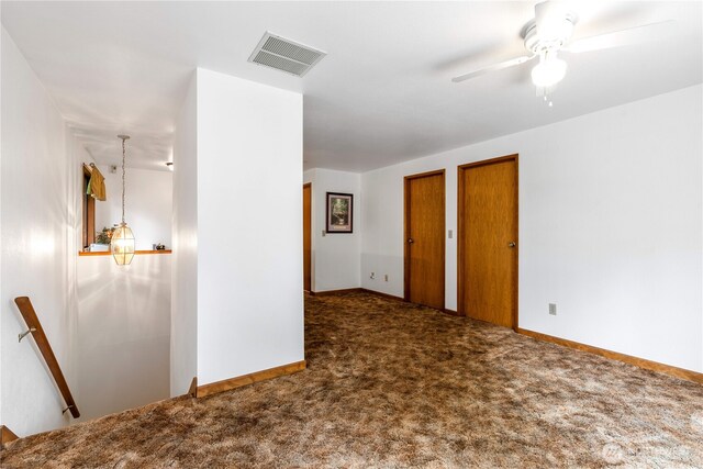 unfurnished bedroom with carpet floors, baseboards, visible vents, and multiple closets