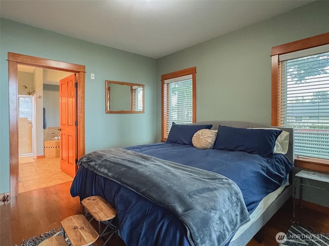 bedroom featuring light wood-type flooring and connected bathroom